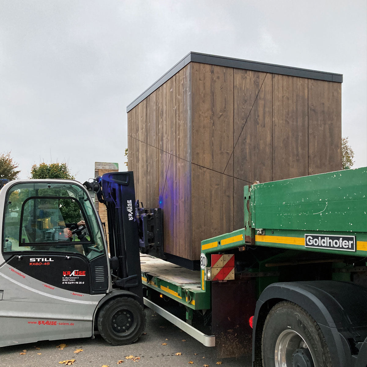 LKW und Gabelstapler bei der Anlieferung des Sanitörcontainers tinyblue